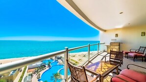 Un balcón con vistas al océano y un área de piscina.