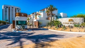 Um hotel moderno com fachada branca, entrada com portão e uma placa com a inscrição "LUNABIANGA".