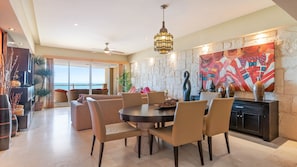 A spacious dining area with a round table and chairs, a stone accent wall, and a large painting.