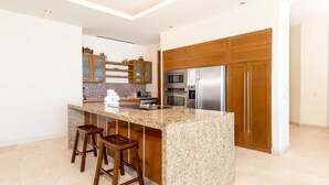A modern kitchen with granite countertops, stainless steel appliances, and wooden cabinetry.