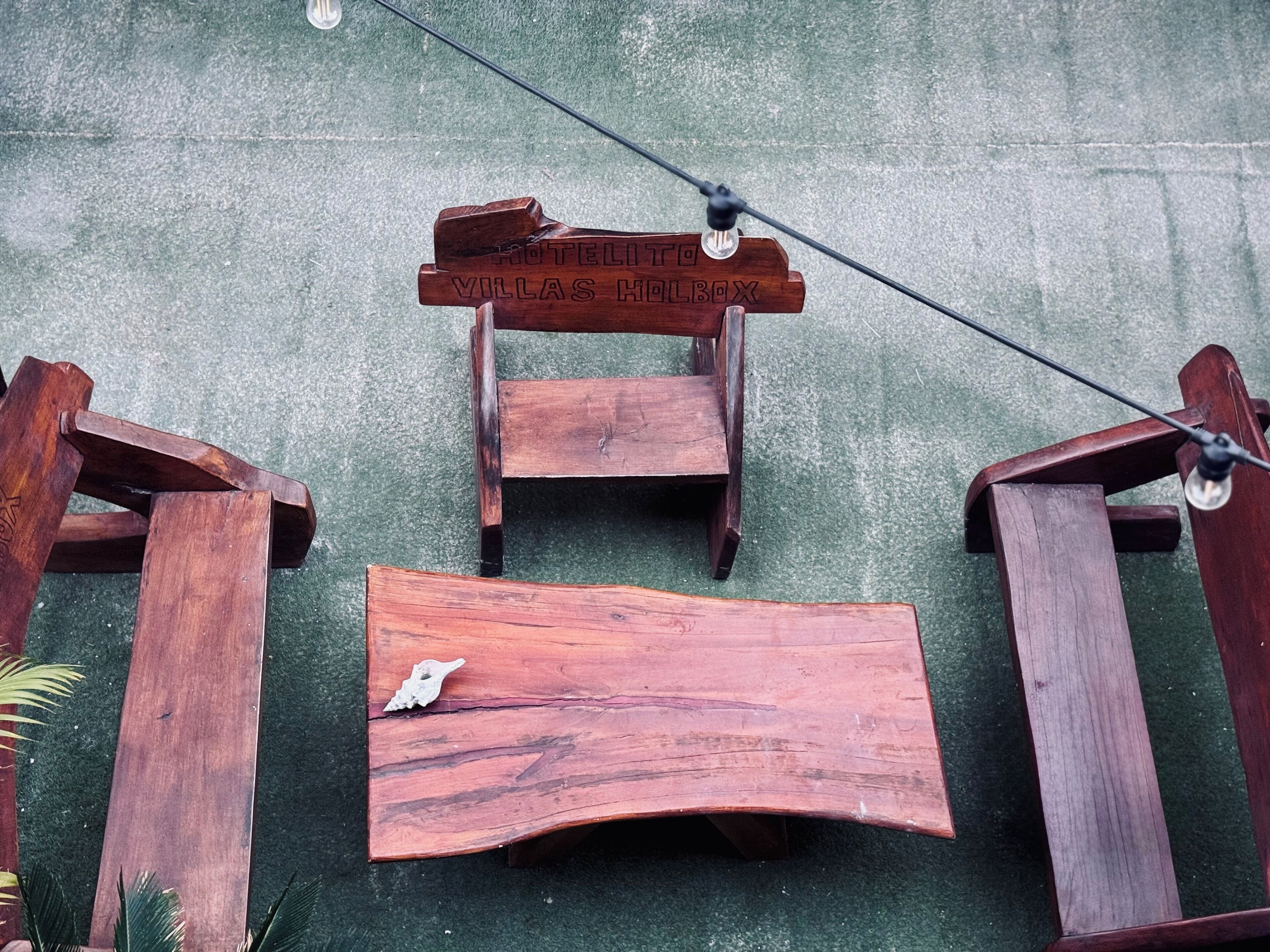 A wooden chair with a sign that reads "HOTEL VILLAS HOLBOX".