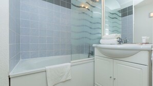 A modern bathroom with a glass shower enclosure, a white bathtub, and a sink with a mirror above it. - Studio Avec Balcon Privé | Accès Piscine (Hourtin)
