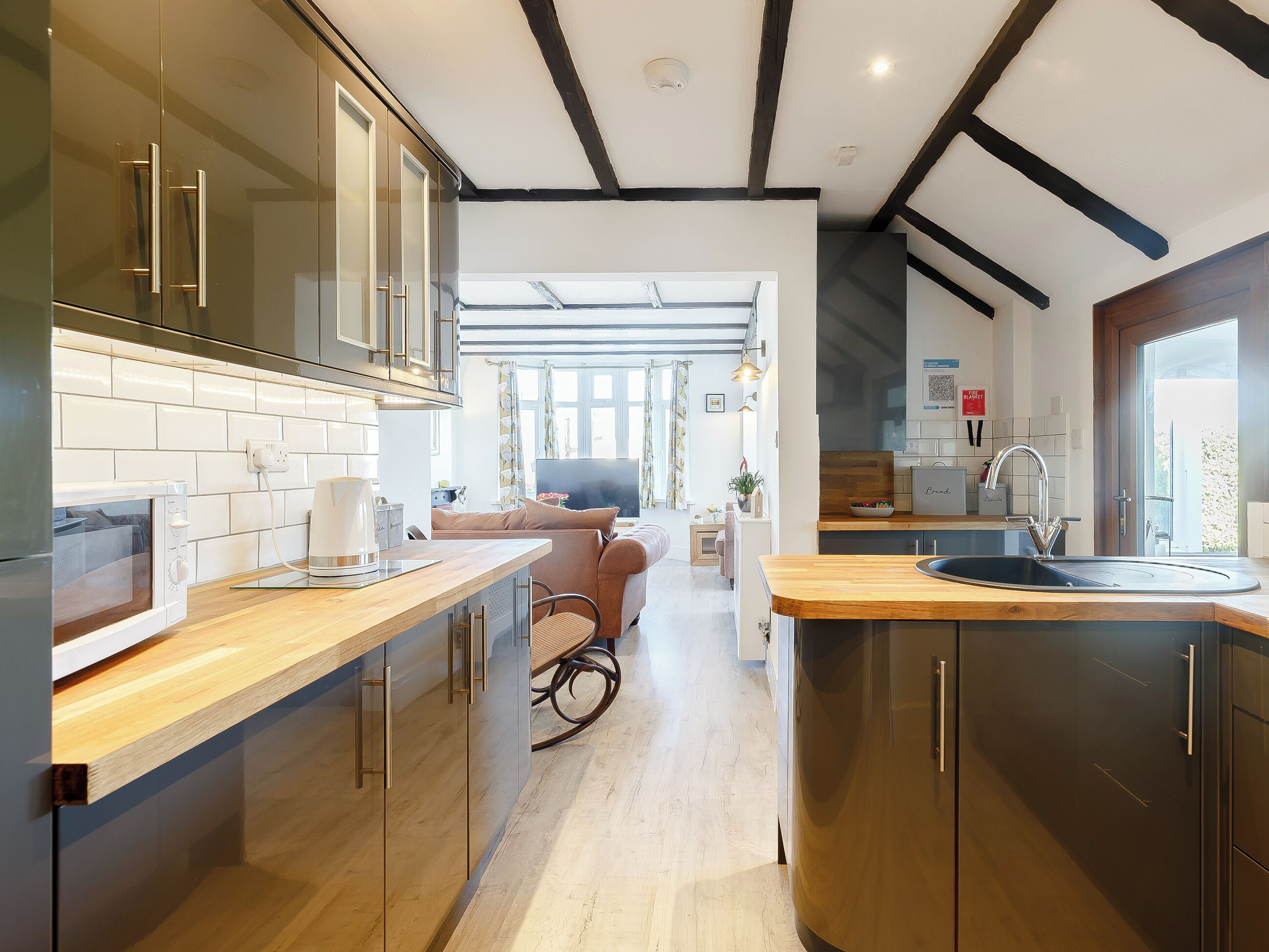 A modern kitchen with wooden countertops, a built-in oven, and a large window.
