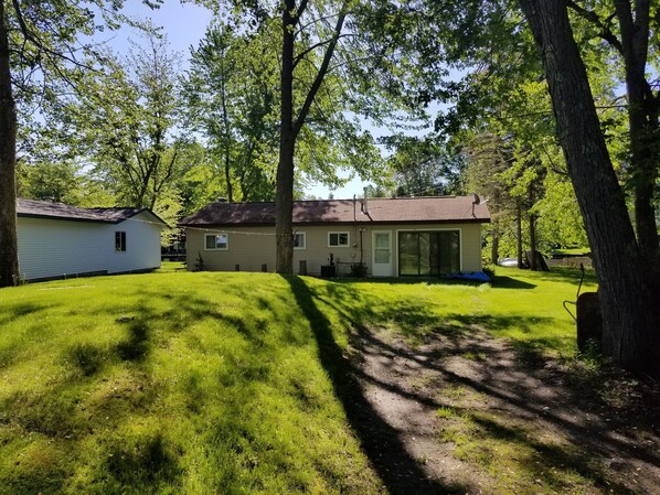 A single-story house with a large front yard, a covered patio, and a garage.
