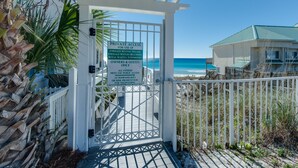 Une entrée fermée par un portail mène à une propriété située en bord de mer, et une pancarte indique qu’elle est réservée à l’usage privé des propriétaires et de leurs invités.