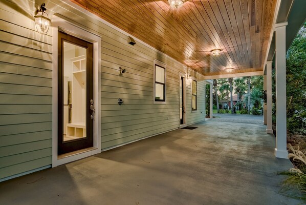 Step outside to a covered porch with a door leading to a cozy interior space.