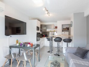 A modern apartment with a dining area, kitchen, and living space.