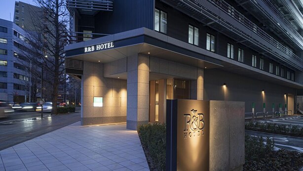 The exterior of the R&B Hotel with a modern design, featuring a prominent entrance and a well-lit facade. -  Washington R&B Hotel Sendai Higashiguchi (Sendai)
