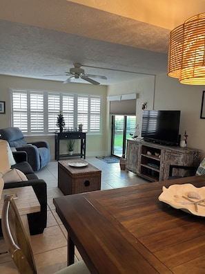 Relax in a comfortable seating area with a sofa and dining table, perfect for unwinding and enjoying the flat-screen television.