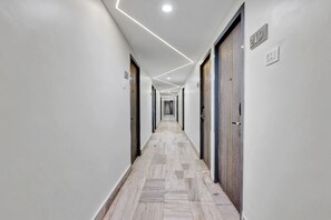 A long, narrow hallway with a tiled floor and white walls. There are doors on both sides, and the number 219 is visible on the wall.
