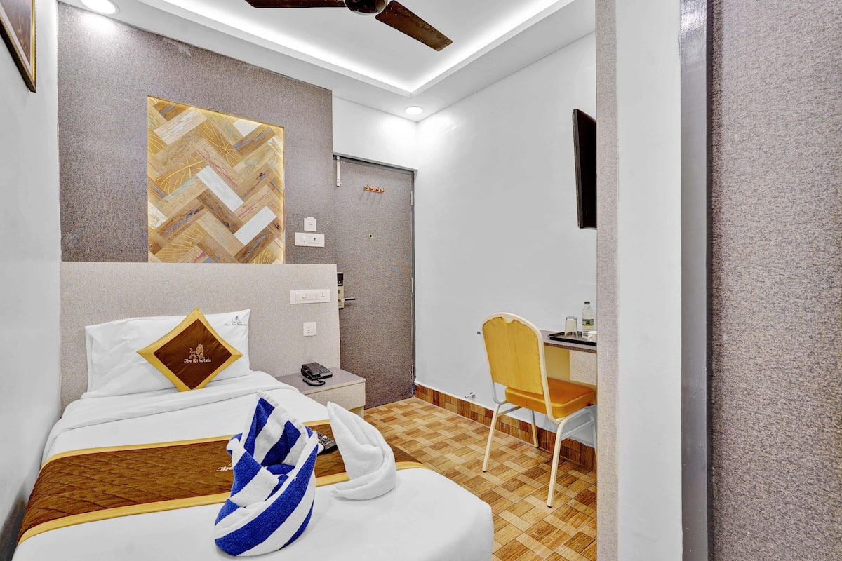 A hotel room with a bed, a desk, and a chair.