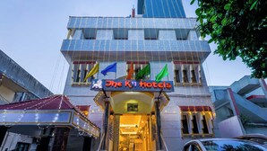 A hotel entrance with a sign reading "The Ki Hotels" and multiple flags. - The K11 Hotels (Chennai)
