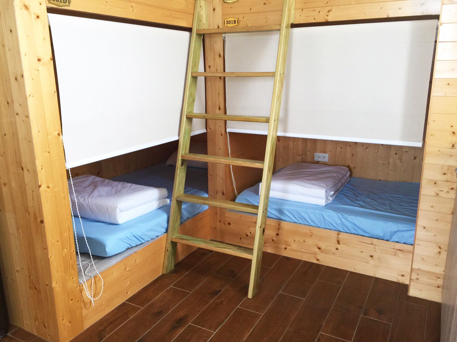 A small, wooden cabin with two bunk beds and a ladder.