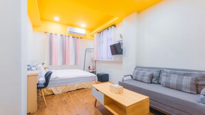 A compact room with a bed, a desk, a sofa, and a TV mounted on the wall. - Hello Inn - Hostel (Magong)
