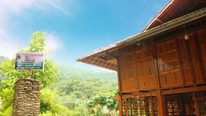 A wooden building with a sign for Fai Thiên Homestay, surrounded by lush greenery and a mountainous backdrop. - I am a local guide,so i can provide the  information tour in my province for you (Ha Giang city)