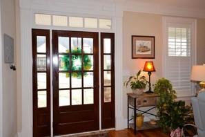 Enter a welcoming space with a dark door, console table, and warm lamp.