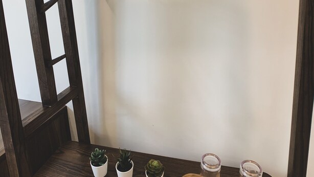 A wooden shelf with three small potted plants and two glass containers. - House 116 (Bangkok)