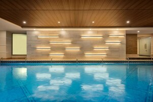 Una piscina techada, sillones reclinables de piscina