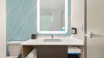 A bathroom with a white sink, a mirror, a towel rack, and a toilet.