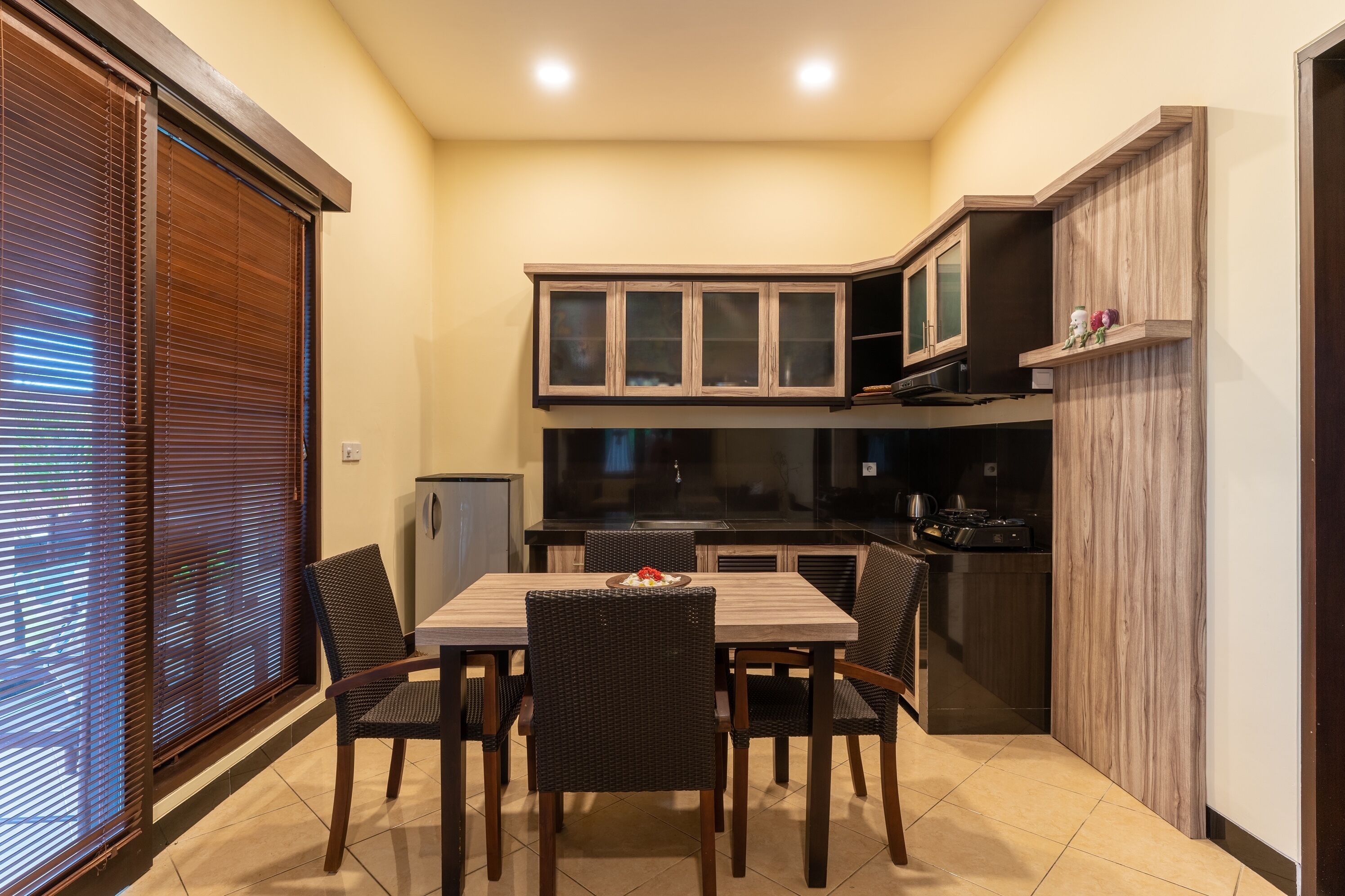 A compact kitchen with a dining table and chairs, wooden cabinets, and a built-in oven.