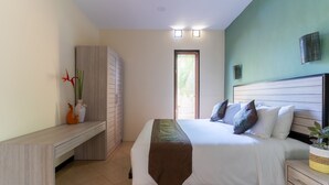 A bedroom with a bed, bedside tables, a wardrobe, and a window with blinds. - Benian Villas (Nusa Dua)