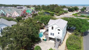 Uma área residencial com diversos estilos de casas, uma piscina e vista para o mar.