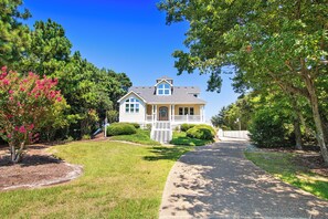 A two-story house with a front porch, a driveway, and a well-maintained lawn. - Soundside, Private Pool, Community Amenities, CC10, Fore-Shore (Corolla)