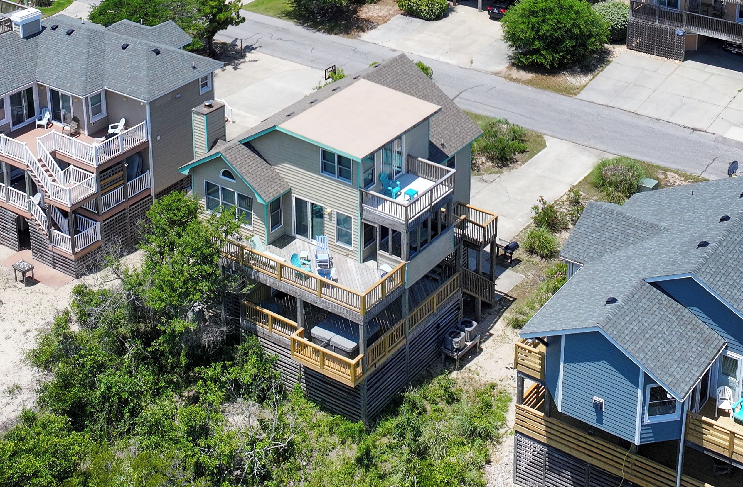 A multi-story residential building with a balcony, a garage, and a driveway.