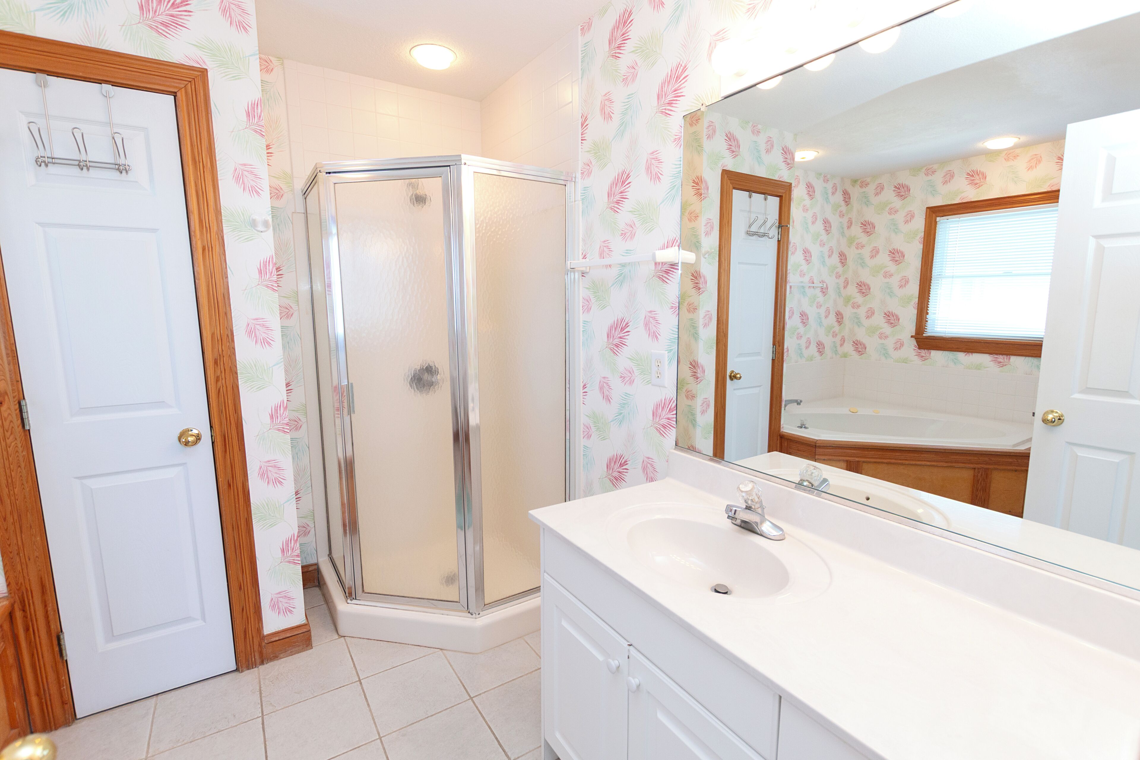 Un baño con ducha, lavabo y espejo.