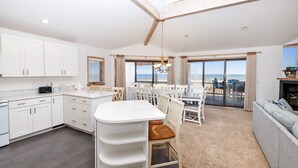 A modern kitchen with white cabinets and a dining area with a white table and chairs.