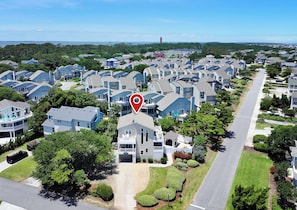 A residential area with houses, a road, and a lighthouse in the distance. - Oceanside, Close to the Beach, Private Pool, Hot Tub! 740, Wild Horses (Corolla)