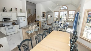 A spacious kitchen with a dining area, featuring a large wooden table and chairs, a built-in oven, and a microwave.