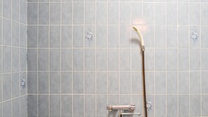Une salle de bain équipée d’une douche, de toilettes et d’un drain.