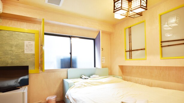 Une chambre d’hôtel avec un lit, une télévision, un bureau et une fenêtre.
