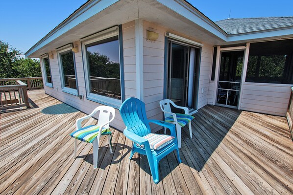 A wooden deck with two Adirondack chairs and a small table. - Oceanside, Private Pool, Hot Tub, Screened Porch, WC940, Whalin (Corolla)