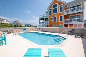 A swimming pool with lounge chairs and a multi-story building with balconies. - Oceanside, Hot Tub, Private Pool, Community Amenities, BU3, Tangerine Dream (Corolla)