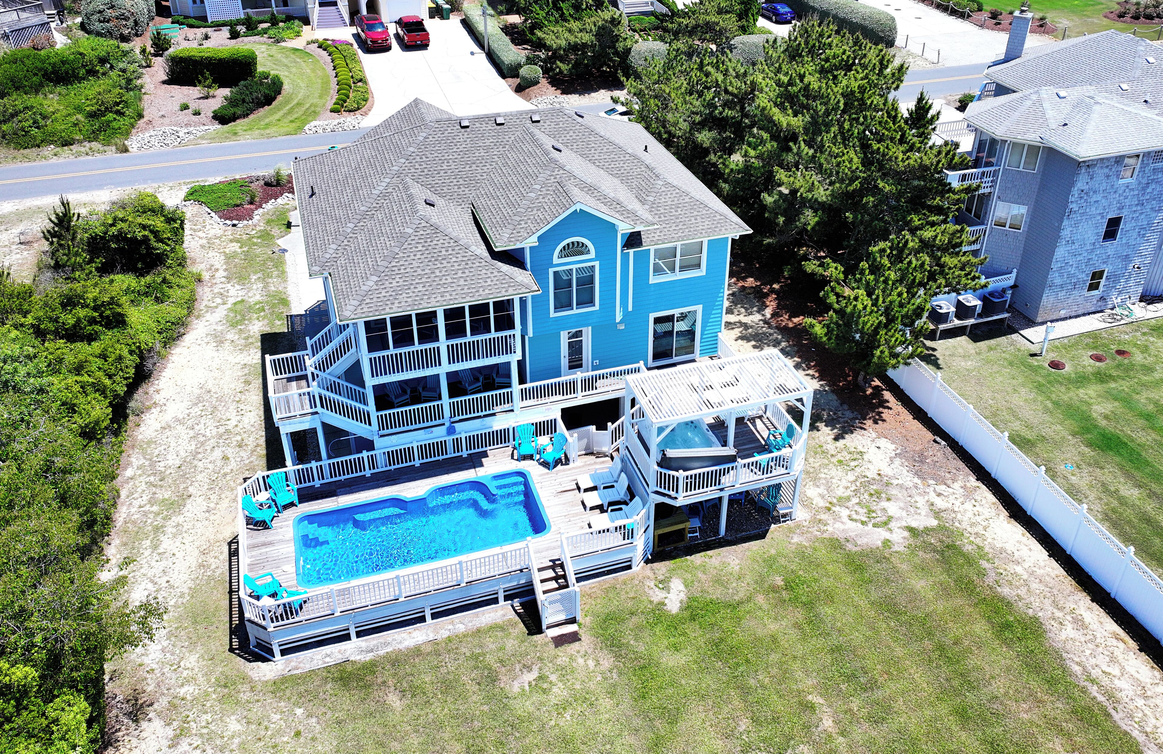 A two-story house with a swimming pool, a deck, and a fenced yard.