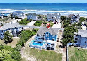 A residential area with houses, a swimming pool, and a view of the ocean.