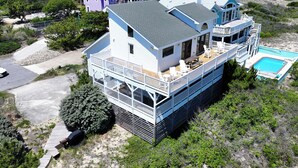 Une maison à plusieurs étages dotée d’un balcon, d’une piscine et offrant une vue sur le quartier environnant.