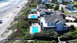 A coastal residential area with houses, a beach, and a swimming pool. - OCEANFRONT, 8 BRs, Rec Rm, Pool, H Tub, Media Rm, Ocean Views, OS24C, Flying Cloud II (Corolla)