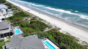 A beachside property with a swimming pool, a deck, and a view of the ocean. - OCEANFRONT, 8 BRs, Rec Rm, Pool, H Tub, Media Rm, Ocean Views, OS24C, Flying Cloud II (Corolla)
