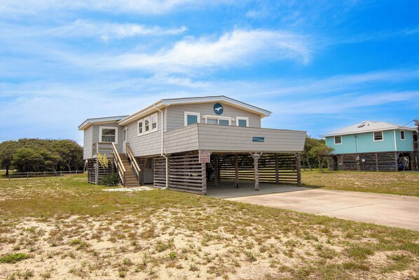 A two-story house with a covered porch and a staircase leading to the upper floor. - Oceanside, Sun Deck, Close to beach! KH106, Annie Oakley (Kitty Hawk)