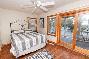 A bedroom with a bed, a ceiling fan, a window with blinds, and a view of the outside deck. - Semi-Soundfront, Rec Room, Private Pool, Hot Tub, 566, Finnegans Wake (Corolla)