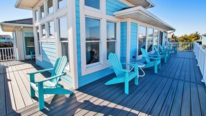 Une maison dotée d’une terrasse comprenant plusieurs chaises et une table.