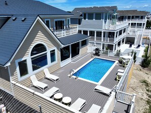 A residential property with a swimming pool, multiple decks, and outdoor seating areas. - OCEANFRONT, Ocean Views, Private Pool, Rec Room, 230, Long Weekends (Corolla)