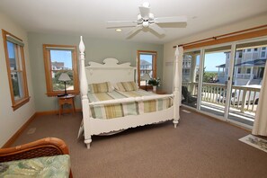 A four-poster bed with a canopy, a ceiling fan, and a view of the ocean through large sliding glass doors. - Semi-Oceanfront, Rec Rm, Pool, Hot Tub, Close to Beach! PI191, OBXcape (Corolla)