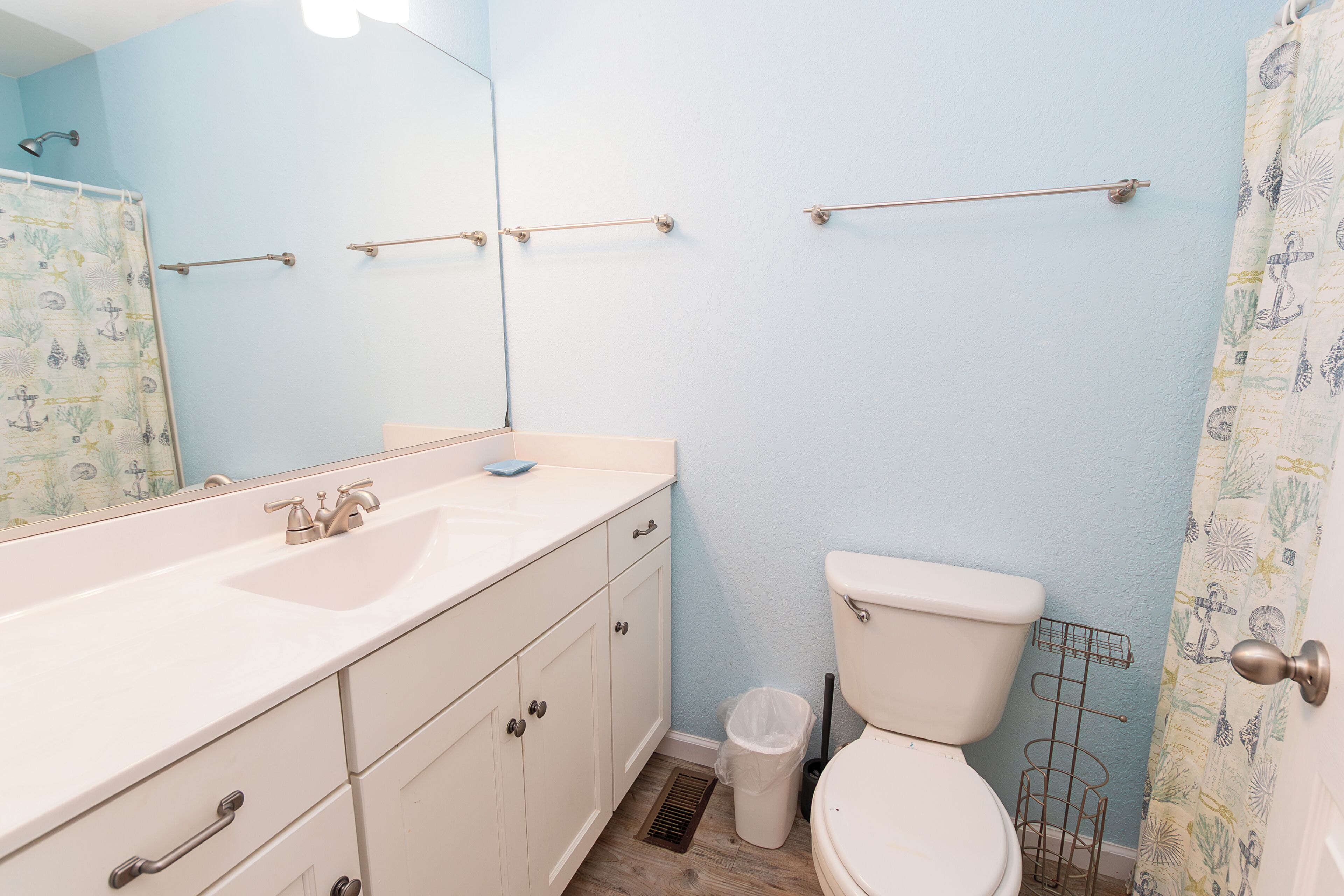 A bathroom with a sink, toilet, and a mirror.