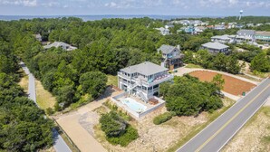 Uma casa grande, de vários andares, com um amplo quintal, incluindo piscina e deck.
