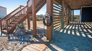A wooden staircase leading to a covered area with a coiled hose hanging on the wall. - Semi-Oceanfront, Pets Welcome, Wild Horses, Ocean Views! 4x1678, Turtle Trax (Corolla)
