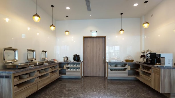 A modern kitchen with granite countertops, stainless steel appliances, and pendant lighting. - Yuan Hsiang Hotel (Yuli)